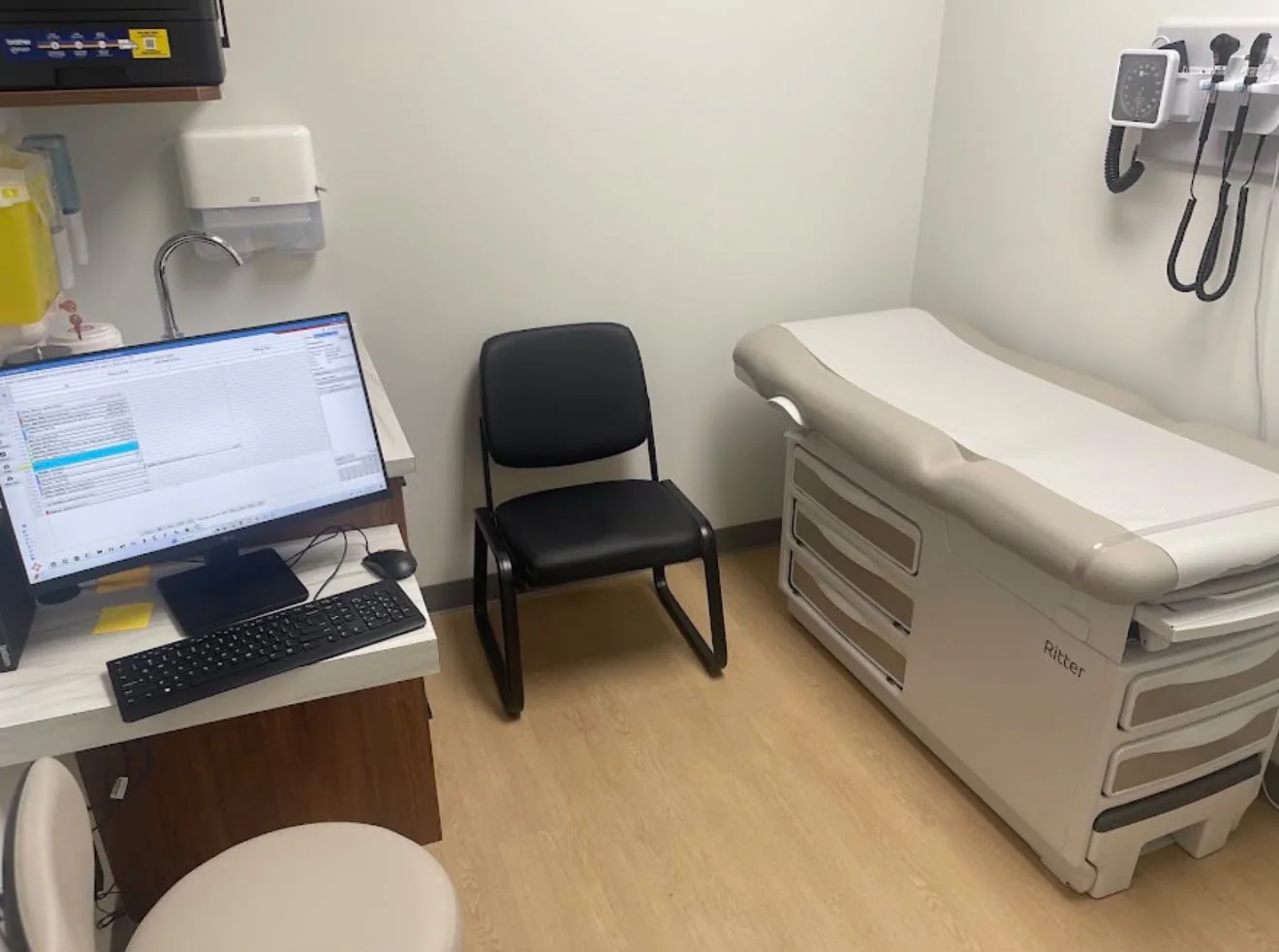 Clean exam room with an examination table and computer